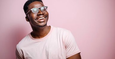 Portrait of handsome black man posing in front of pink background